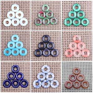 Various natural stone donut beads including malachite and opal for jewelry making