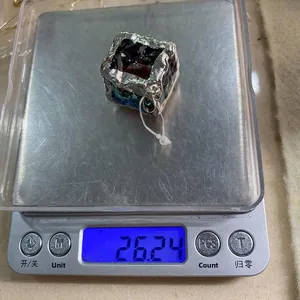 Vue détaillée d'un pendentif cube en cristal de 23 mm sur une balance pesant 26,24 grammes