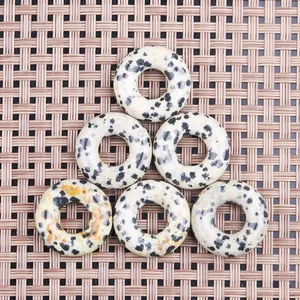 Set of 6 Dalmatian Jasper donut pendants on a woven background for DIY jewelry making