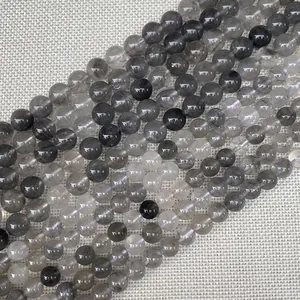 Dettaglio di perle tonde in pietra naturale grigio-nera con inclusioni interne