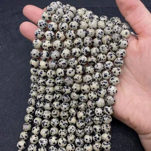 Close-up of Dalmatian Jasper beads showing natural black spots and smooth round texture