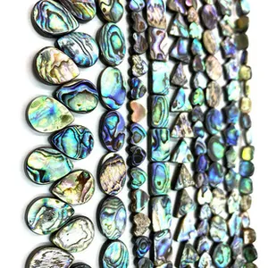 Macro shot of assorted natural abalone shell beads in triangle and teardrop shapes