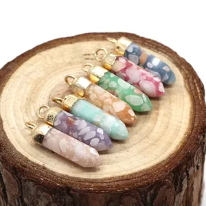 Set of seven hexagonal natural stone pendants with golden clasps on wood background