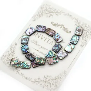 Macro view of rectangular natural abalone shell beads with rainbow luster and organic textures