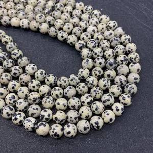 Macro shot of natural Dalmatian Jasper round beads with black spotted texture for DIY jewelry
