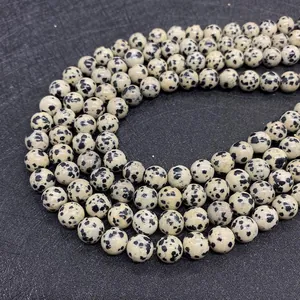 Macro shot of natural Dalmatian Jasper round beads with black spotted patterns
