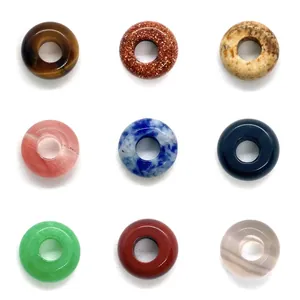 Variety of polished natural gemstone donut beads including tiger eye and lapis lazuli