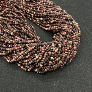 Macro detail of 2-4mm faceted natural stone beads with mixed pink and black patterns
