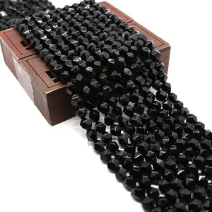 Close-up of faceted black onyx beads on a vintage wooden box for DIY jewelry making