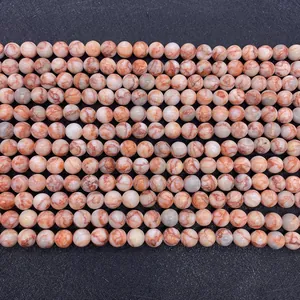 Detailed macro view of natural red web stone round beads with polished marble texture