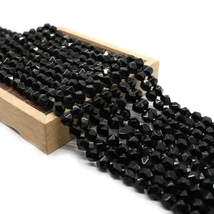 Macro shot of faceted black onyx loose beads on a wooden tray for jewelry making