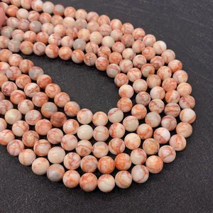 Macro detail of round red network stone beads with natural marble texture for DIY jewelry