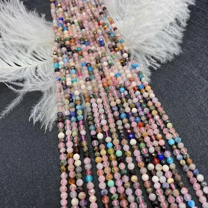 Macro shot of 3mm colorful faceted natural stone beads on black background with white feathers