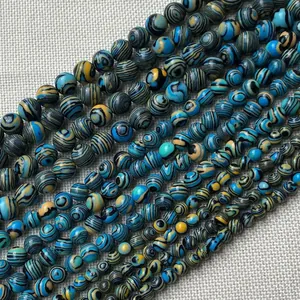 Macro detail of blue and yellow malachite style round beads on textured fabric