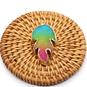 Macro detail of rainbow crystal leaf pendant with gold metallic plating and glitter texture