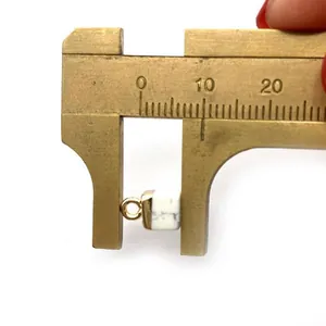 Precision measurement of square white stone pendant with gray marble texture using a caliper