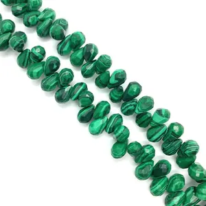 Detailed macro view of faceted green malachite teardrop beads for DIY jewelry making