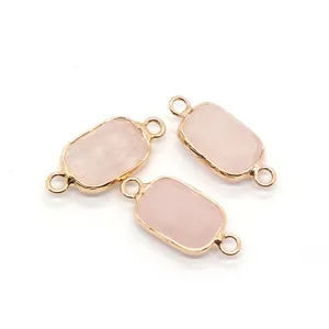 Detail of three rectangular rose quartz connectors with gold borders for DIY jewelry making