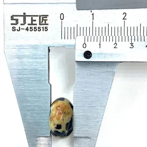 Makroaufnahme einer 10mm Dalmatiner-Jaspis Perle, die mit einem Messschieber gemessen wird