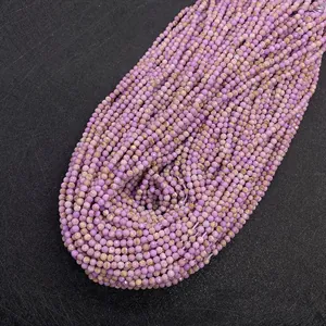 Macro detail of faceted purple natural stone beads on a textured dark background