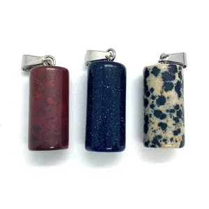 Macro view of cylindrical stone pendants with silver metal bails on white background