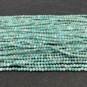 Detailed macro view of faceted natural amazonite round beads on grey stone background