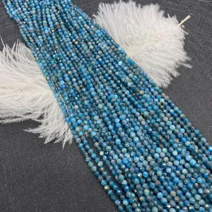 Dettaglio ravvicinato di perline tonde in apatite blu sfaccettata con piume bianche