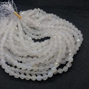 Close-up of faceted white agate beads showing glossy polished texture on dark fabric