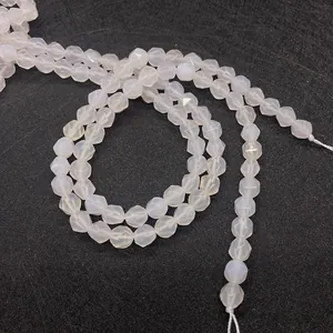 Macro detail of faceted white agate loose beads showing geometric texture on black background
