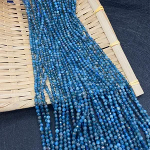 Dettaglio macro di perline sfaccettate in apatite blu naturale su vassoio di bambù