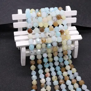 Macro shot of faceted natural amazonite beads on a white miniature bench prop