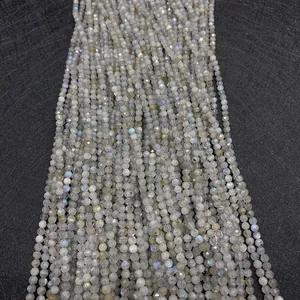 Macro shot of faceted natural labradorite beads showing blue and green flash on dark texture