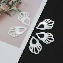 Detail von fünf weißen fächerförmigen hohlgeformten Anhängern für DIY-Schmuck