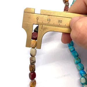 Makro-Detail von 8mm bunten Kaiserstein-Perlen, mit einem Messschieber gemessen