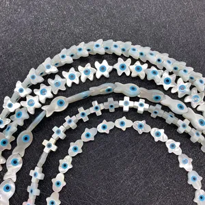 Natural white shell beads set with evil eye patterns in various geometric shapes