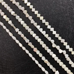 Macro view of natural white mother of pearl beads in heart, clover and drop shapes