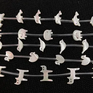 Makro-Detail von weißen Perlmutt-Tierperlen für die DIY-Schmuckherstellung