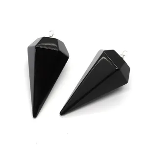 Détail macro de pendentifs en prisme hexagonal en pierre noire polie avec fermoirs argentés