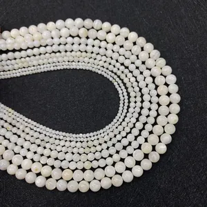 Detailopname van natuurlijke witte schelpkralen in verschillende maten voor DIY-sieraden