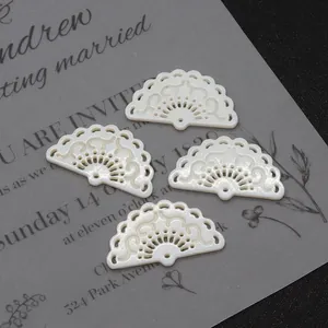 Détail de quatre pendentifs en nacre en forme d'éventail avec motifs ajourés raffinés