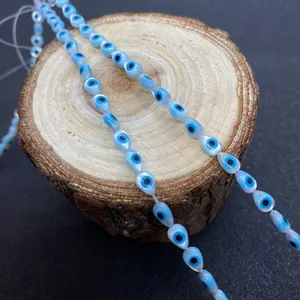 Hellblaue Tropfenperlen mit bösem Blick an weißer Schnur für DIY-Schmuck und Basteln