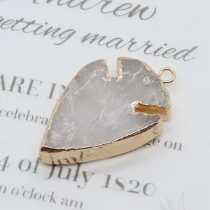 Détail d'un pendentif en cristal blanc en forme de feuille avec bords dorés et bélière