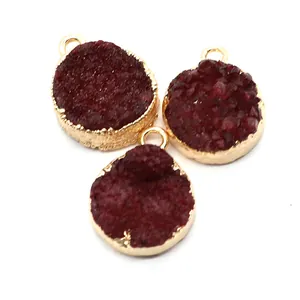 Vue macro de trois pendentifs ronds en cristal druzy bordeaux avec bordure en métal doré