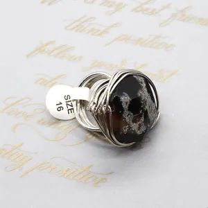 Macro shot of silver wire wrapped irregular natural agate ring with white size 16 label