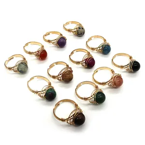 Lot de 12 bagues artisanales en fil de fer avec diverses perles de pierre naturelle sur fond blanc