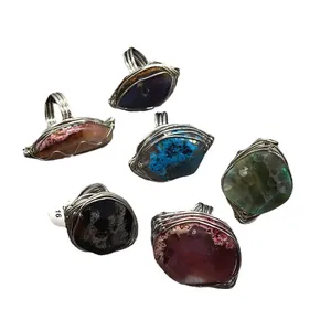 Set of six handmade wire wrapped natural agate crystal rings on white background