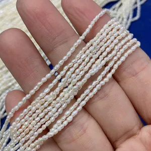 Vista macro di piccole perle d'acqua dolce bianche da 2mm a forma di riso per gioielli DIY