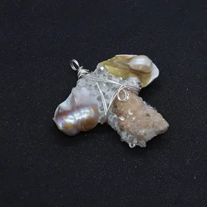 Détail du pendentif artisanal en perle baroque et grappe de cristal brut enveloppé