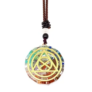 Close-up of Orgone energy stone pendant with colorful natural stones and gold geometry