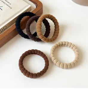 Detailed view of elastic coffee-toned hair ties with soft ribbed fabric texture